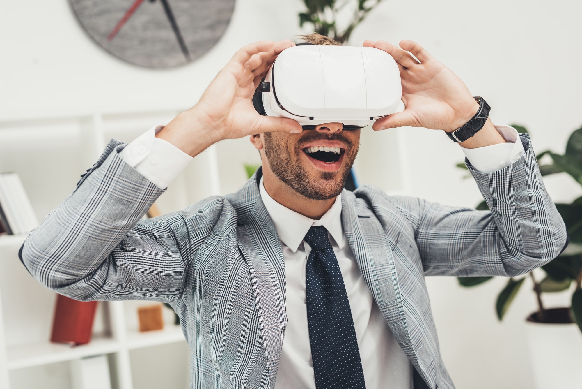 happy young businessman in vr headset sitting in office