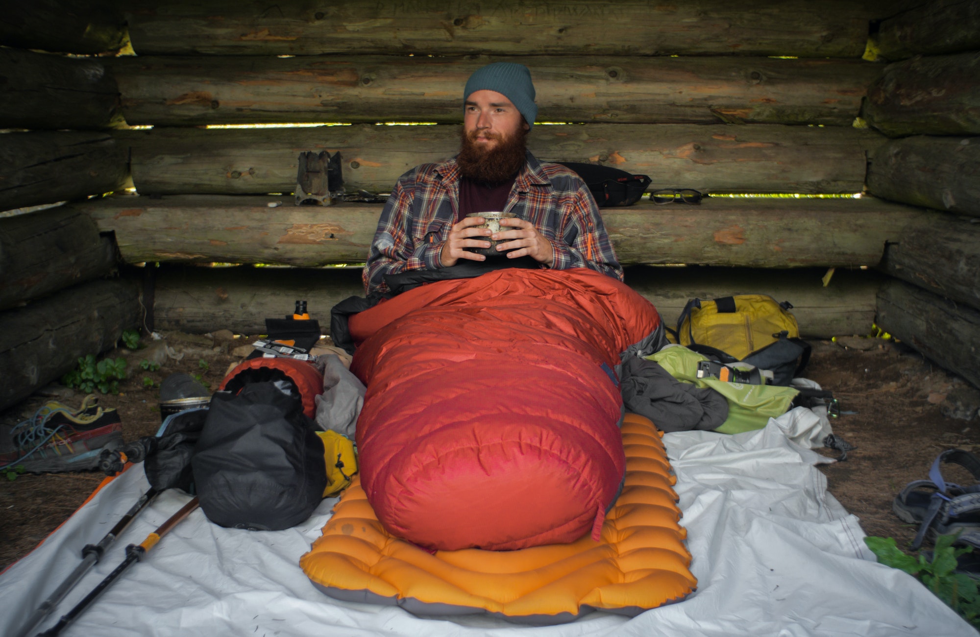 portrait of a caucasian male hiker laying on the ground in his sleeping bag